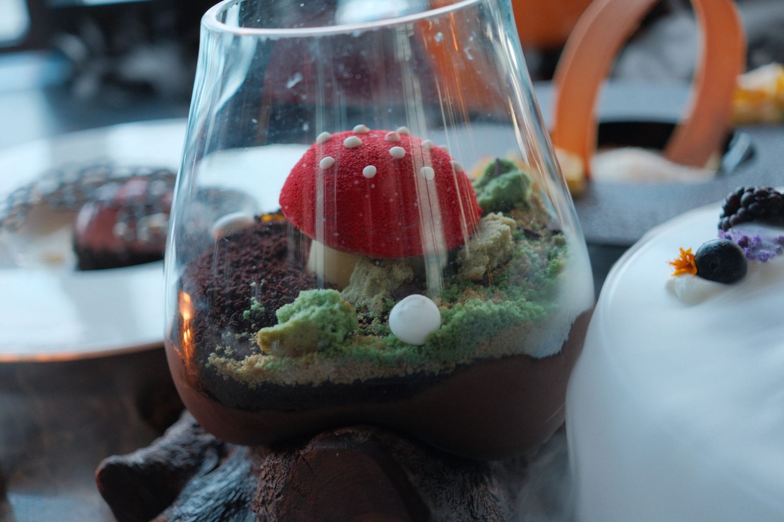 A whimsical dessert in a glass, a red mushroom on an edible forest floor