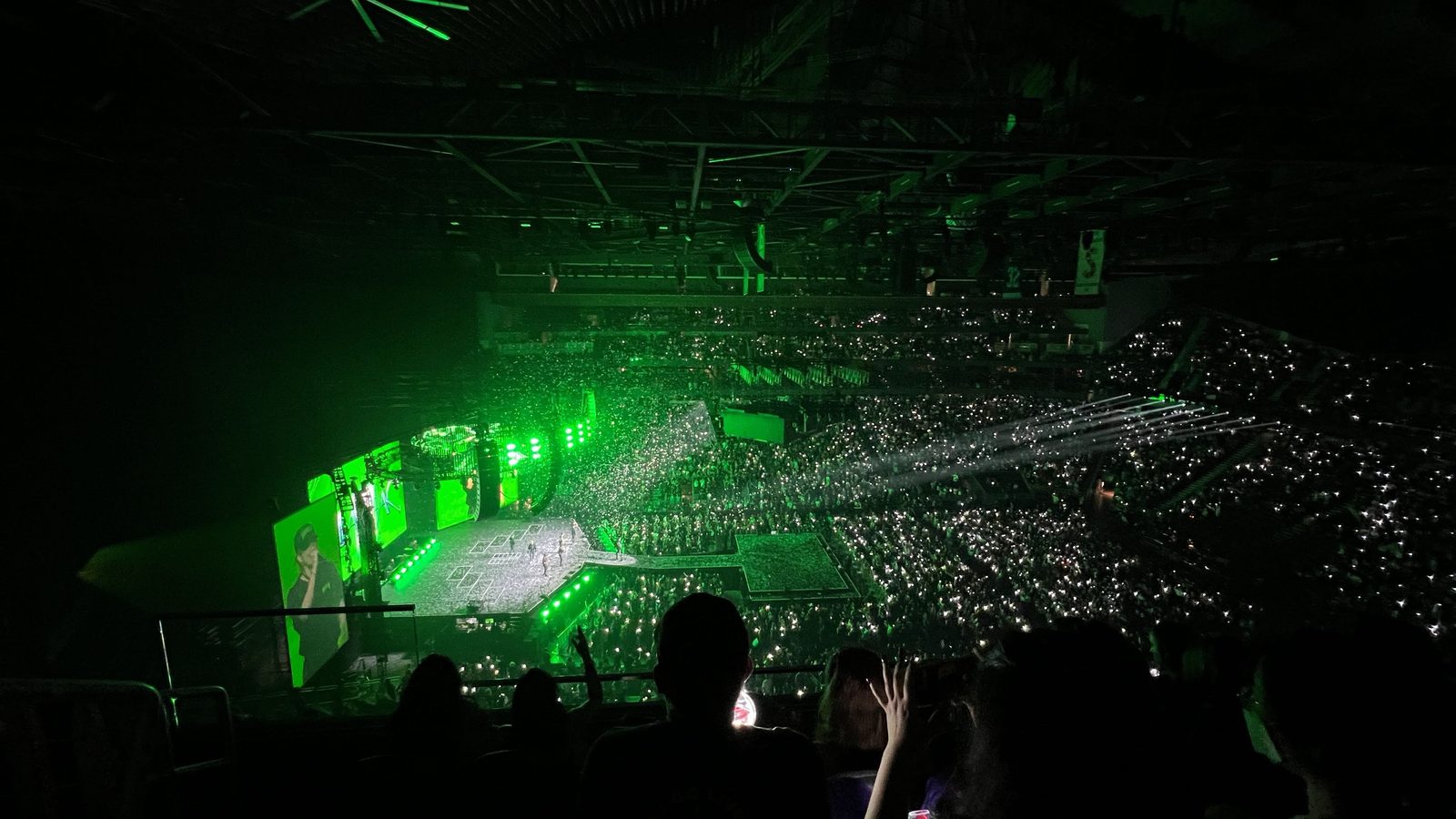 Stray Kids performing at the MANIAC World Tour, Jul 2022, the arena glowing green with a sea of lightsticks