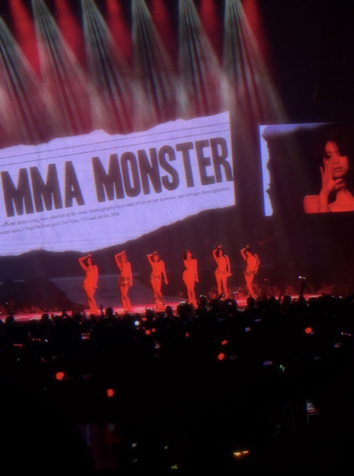 BABYMONSTER performing at HELLO MONSTERS, Sep 2025, the group on stage with a bold graphic on the arena screen