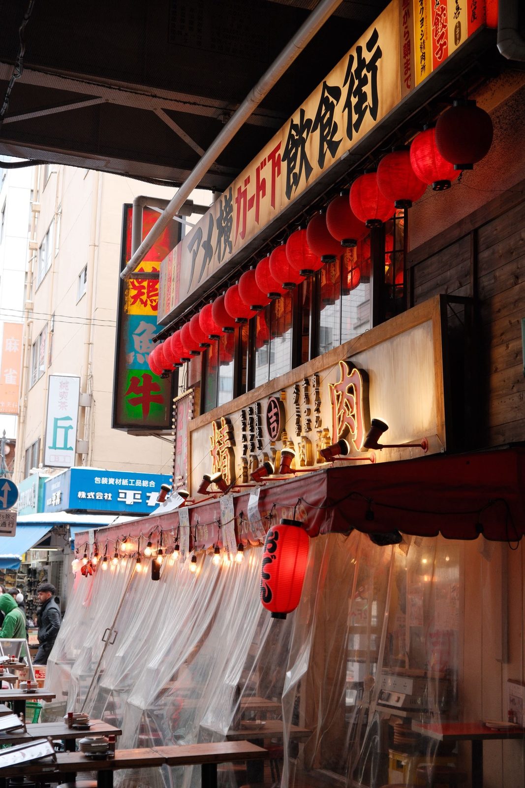 A row of red lanterns outside a Japanese restaurant alley