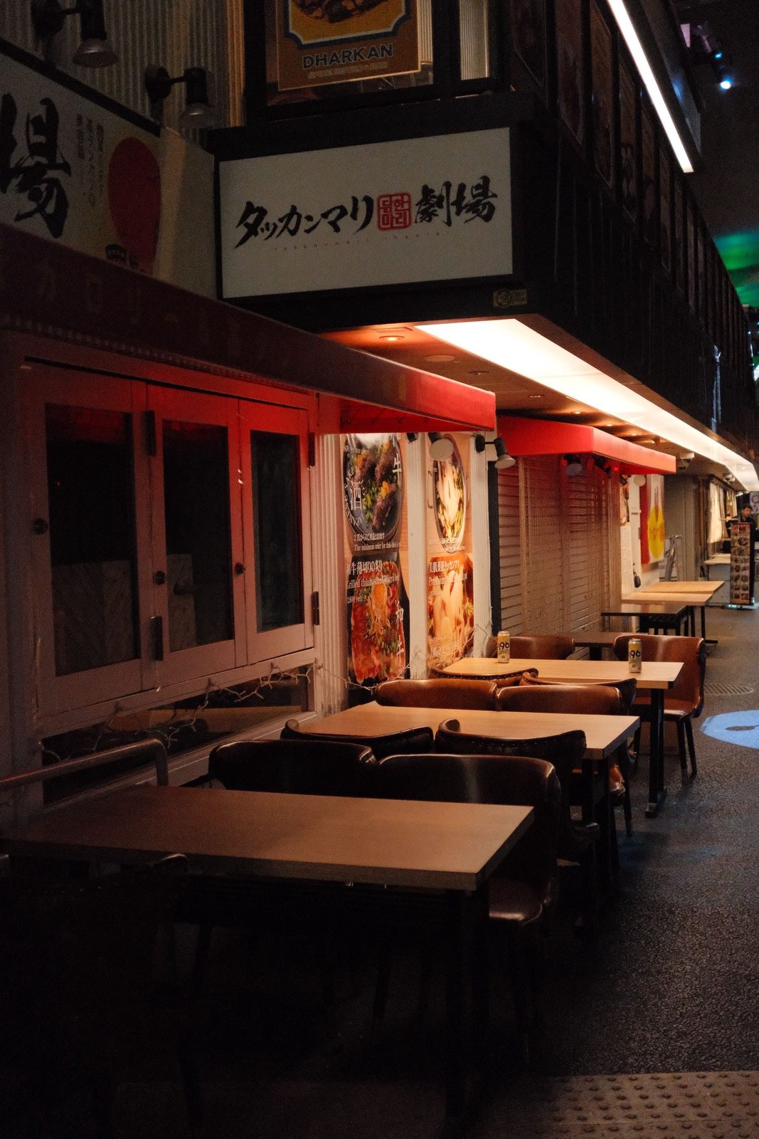 Empty tables outside a Japanese restaurant at night