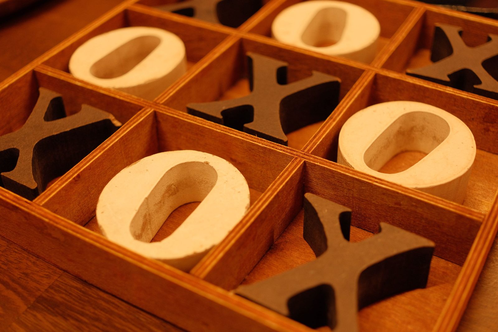 A wooden noughts-and-crosses board mid-game