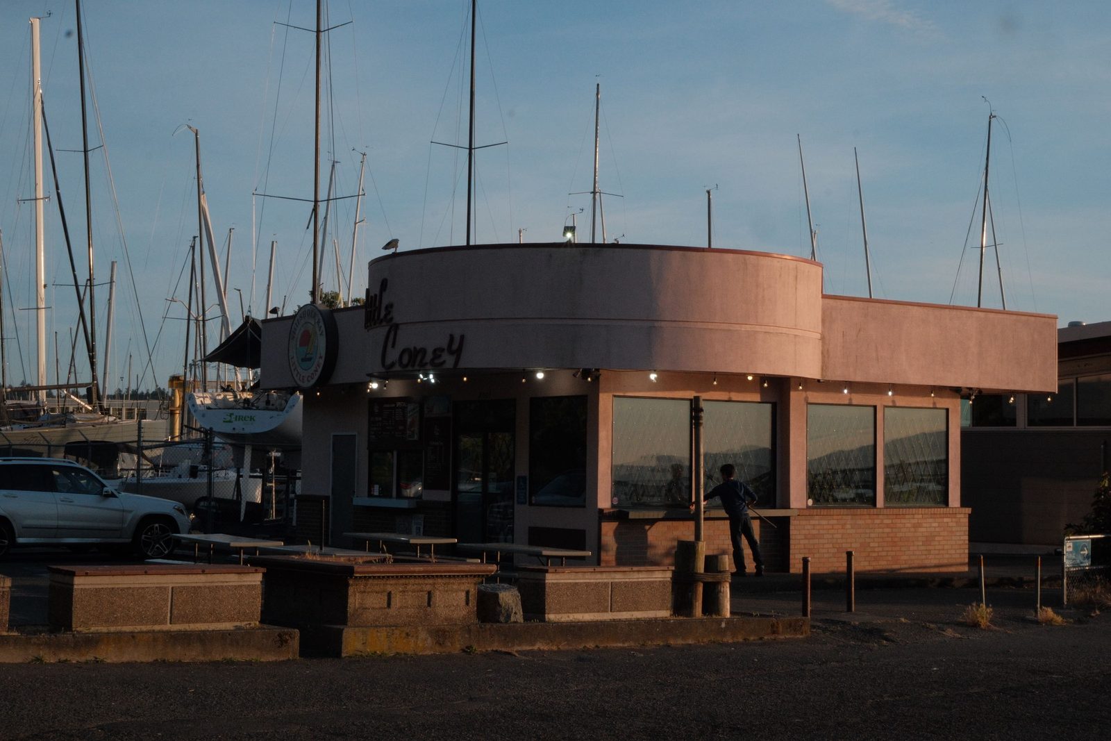 A round mid-century diner by the marina at golden hour