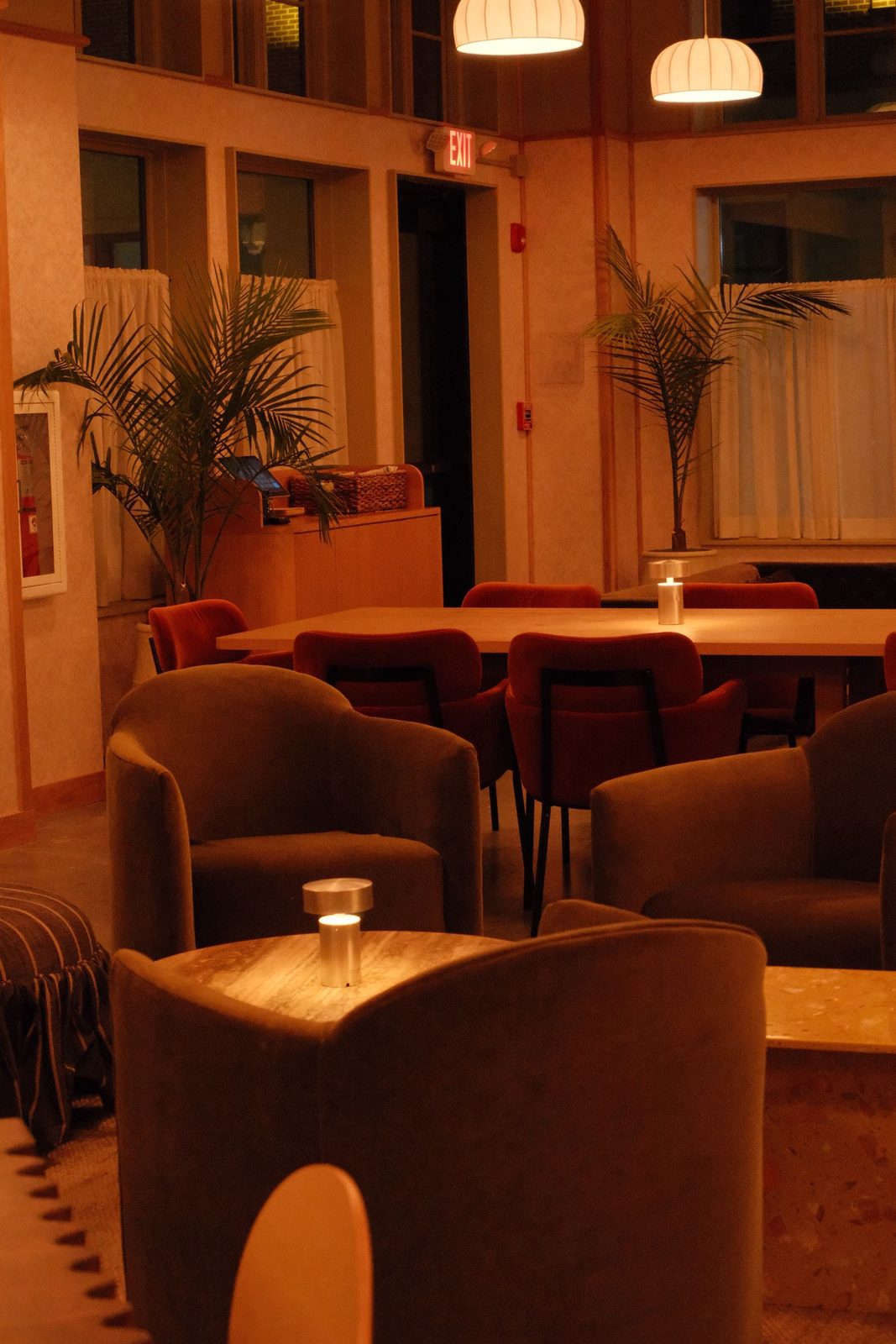 A warm hotel lobby lounge with velvet armchairs