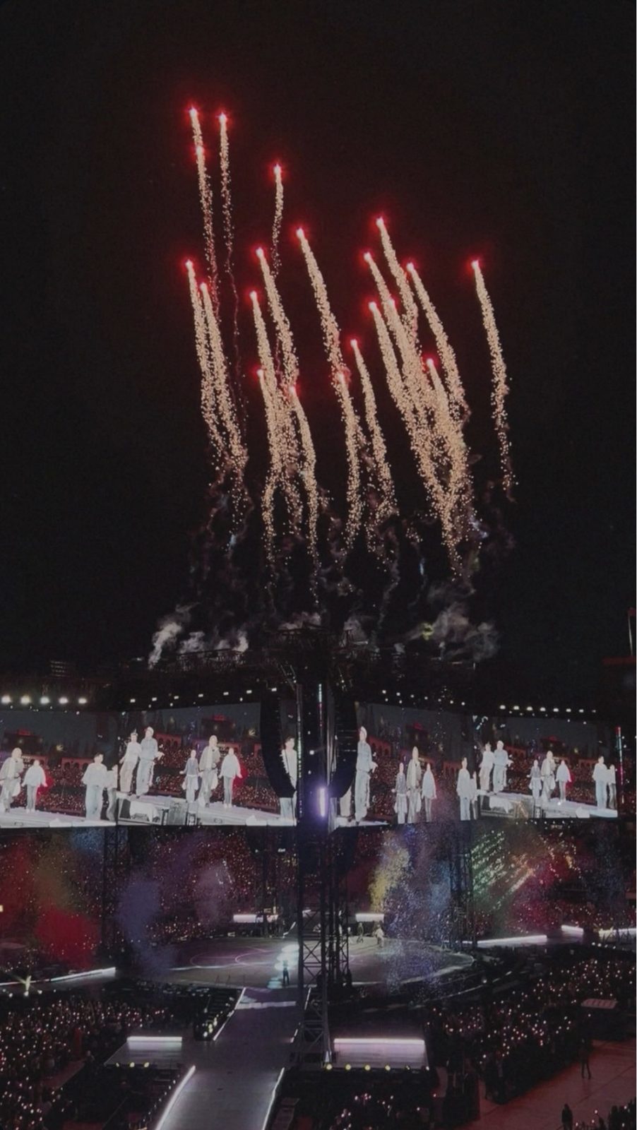 Fireworks erupting over the stage at a stadium concert