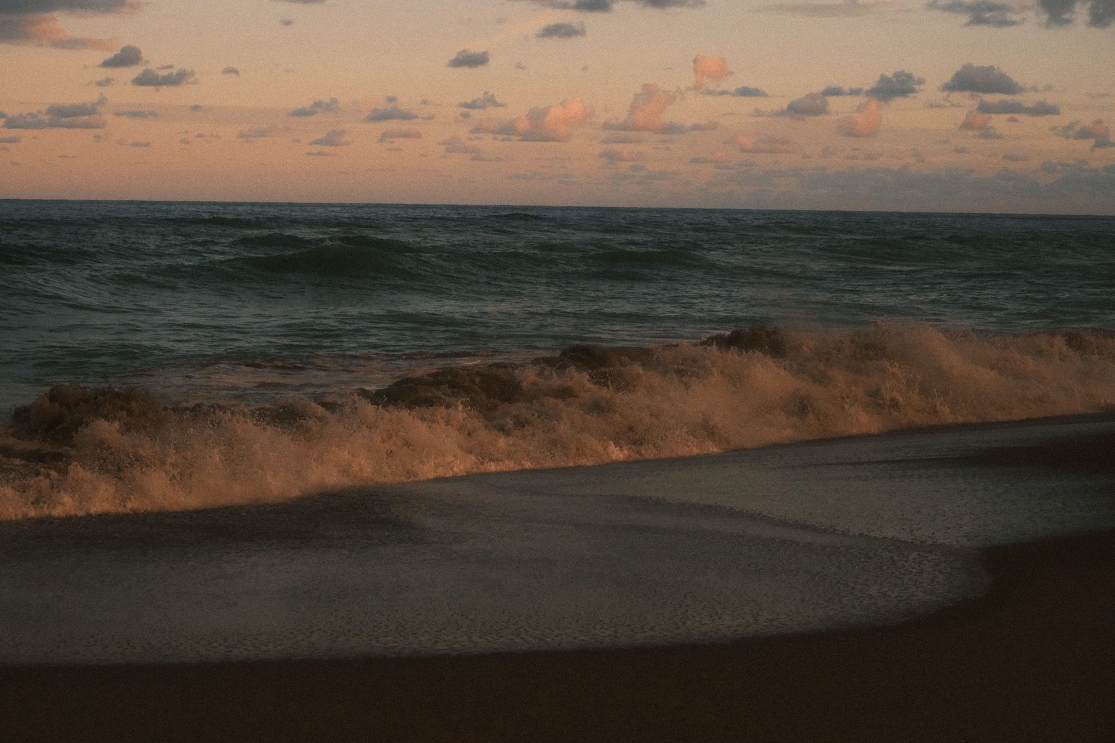 Waves breaking on the shore at dusk
