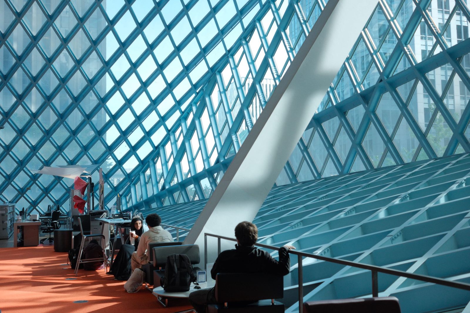 The diamond-glass interior of the Seattle Central Library, readers in the orange reading room