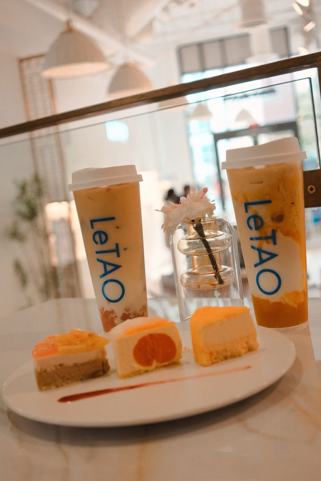 Iced LeTAO drinks beside a row of fruit cheesecake slices