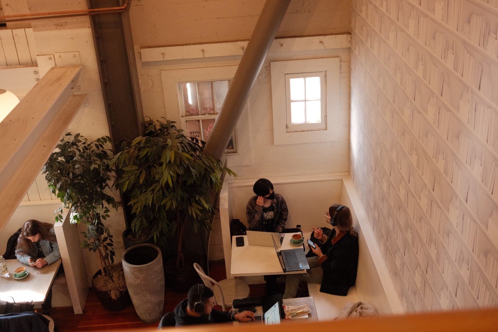 A cafe seen from above, people working in cozy wooden booths