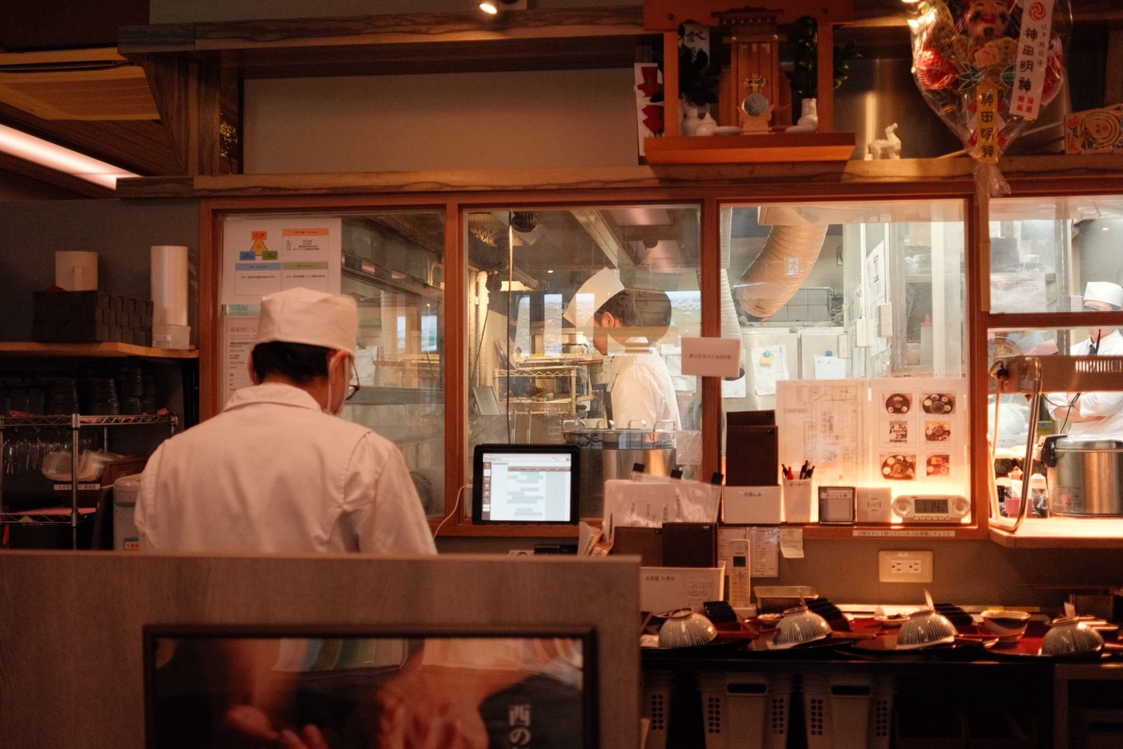 Chefs at work behind the glass of an open restaurant kitchen
