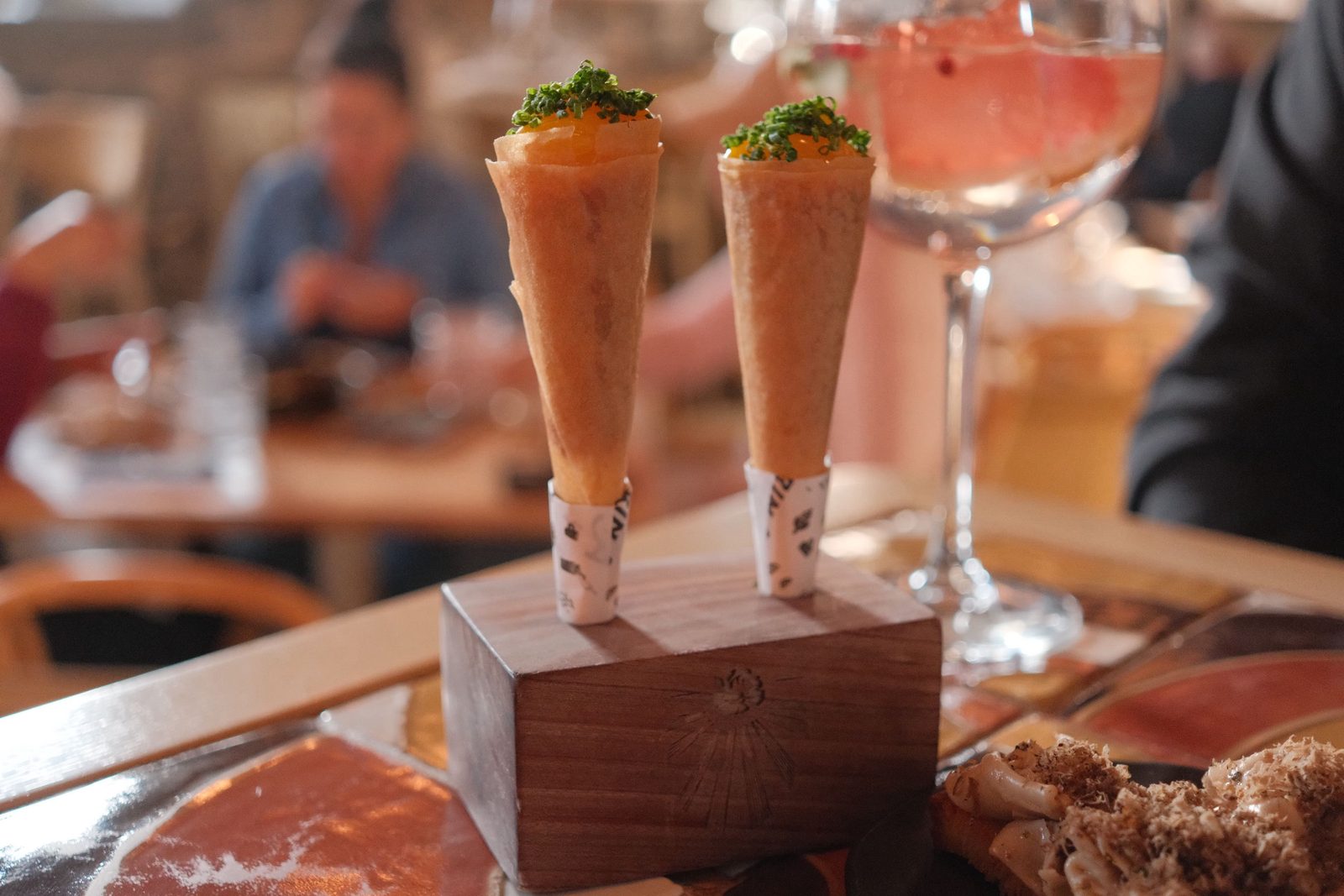 Two savoury cones standing in a wooden block on a dining table