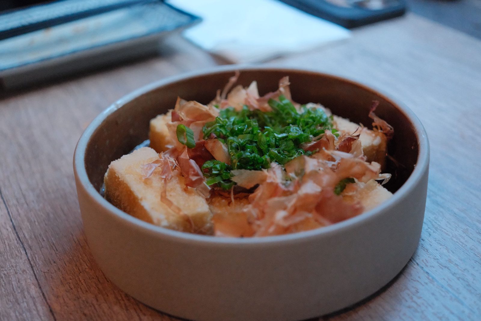 Agedashi tofu topped with bonito flakes and scallions