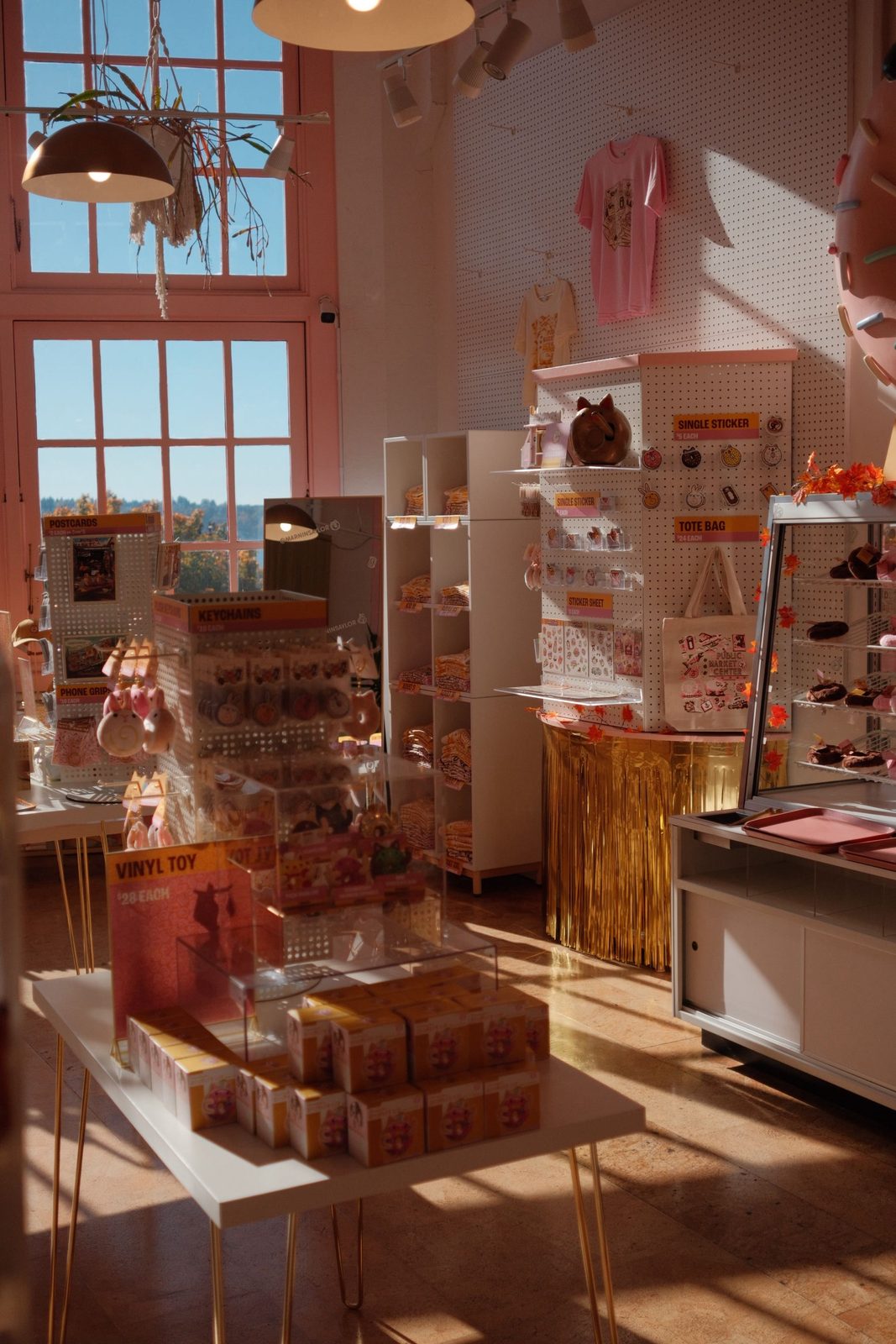 A sunlit pink gift shop full of vinyl toys, stickers, and totes